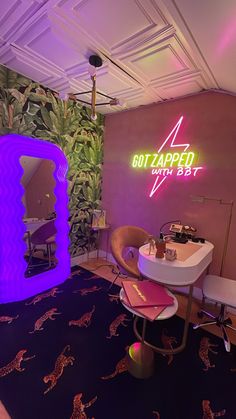 a bathroom with a mirror, sink and stools in front of a plant wall