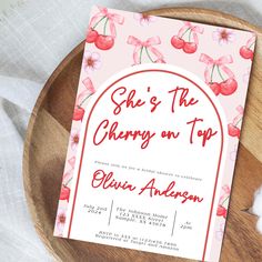 the cherry on top party card is sitting on a wooden plate next to some napkins