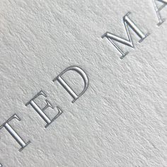 close up of the letters and numbers on a business card that is printed with silver foil