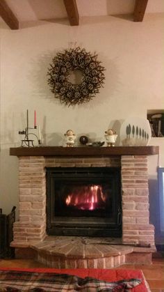 a living room with a fire place in the center and a wreath on the wall