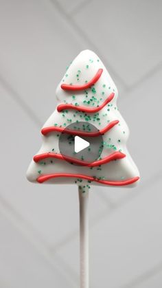 a white and red christmas tree lollipop with sprinkles on it