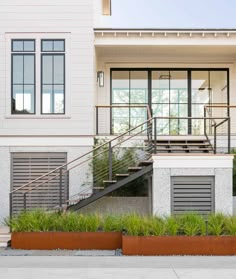 a modern house with stairs leading up to the front door