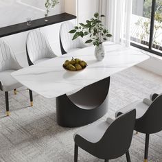 a dining table with chairs around it and a bowl of fruit on the table next to it