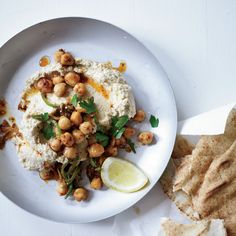 a white plate topped with food next to pita bread