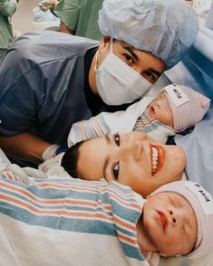 a group of people in scrubs and masks laying on a hospital bed with their babies