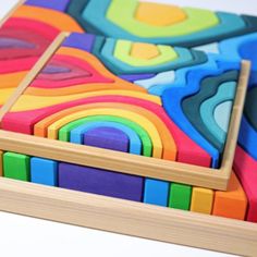 colorful wooden blocks are stacked on top of each other in the shape of a square