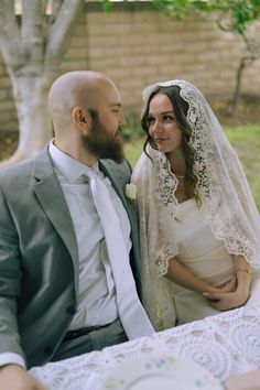 a bride and groom are sitting at a table