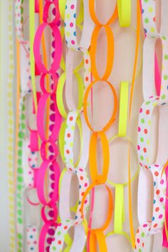 colorful paper streamers are hanging on the wall with polka dots and circles around them