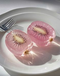 two slices of kiwi on a plate with a fork