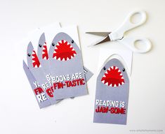 two shark shaped bookmarks with scissors next to them that read, reading is fun