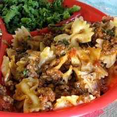 a red bowl filled with pasta and meat