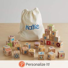 a bag filled with wooden blocks sitting on top of a table next to it's contents