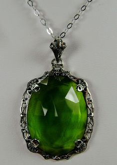 "Simulated Green Peridot Pendant Bubble Design#P10 Custom Made Inspired by Victorian era designs, I now offer this lovely Antique reproduction in sterling silver. The flawless simulated/man-made 22ct faceted green peridot gemstone is 24mm long (15/16th\") and 18mm in width (3/4th\"). The entire pendant is 1.5\" long and 7/8\" wide. The chain (if chosen) is between 18-20 inches in length and is marked 925 as well. Notice the beautiful craftsmanship of the Victorian filigree setting. This pendant Green Jeweled Necklaces For Anniversary, Green Jeweled Necklace For Anniversary, Elegant Lime Green Gemstone Necklace, Elegant Lime Green Jewelry For May Birthstone, Elegant Lime Green Necklace Gift, Elegant Lime Green Necklace For Gift, Antique Green Jeweled Necklaces, Antique Green Jeweled Necklace, Antique Green Oval Jewelry