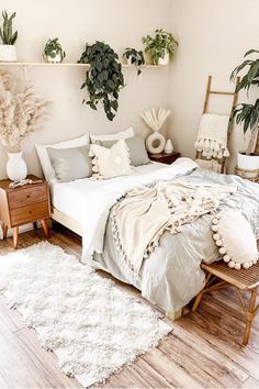 a bed sitting in a bedroom next to two potted plants