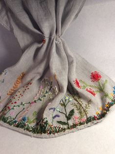 Add a touch of nature to your outfit with this beautiful floral scarf. Hand embroidered with intricate floral designs, this scarf is made of 100% linen and has a lightweight gauze-like texture. Perfect for women who love multifunctional accessories, this rectangle scarf can be worn in a variety of styles. The gray color and embroidered accents make it a perfect addition to any outfit. Dress up a casual look or add a touch of elegance to a formal dress. This scarf is a must-have for any wardrobe. Hand Embroidered Scarf, Bohemian Linen Shawl, Bohemian Linen Scarves For Spring, Bohemian Embroidered Scarves For Spring, Embroidered Bohemian Scarf For Spring, Embroidered Bohemian Scarves For Spring, Scarf Embroidery, Embroidery Scarf, Beaded Scarf