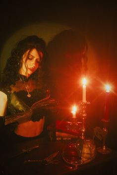 a woman sitting in front of a lit candle