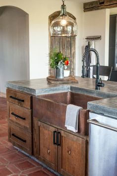 a kitchen with an island, sink and dishwasher in the middle of it