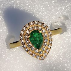 This is part of Chairish’s Fine Jewelry assortment.  Exquisite Brazilian Emerald & White Sapphire Ring in Gold Rhodium Over Sterling Silver Elevate your style with this stunning pear-shaped Brazilian Emerald ring, surrounded by two sparkling rows of white sapphires, all set in gold rhodium over sterling silver. This elegant dinner ring boasts a deep green 0.73-carat Brazilian emerald that will captivate with its rich hue and timeless beauty.  Key Features: 0.73-Carat Pear-Shaped Brazilian Emeral Teardrop Emerald Ring With Brilliant Cut, Pear-shaped Emerald Ring For Anniversary, Elegant Pear-shaped Halo Design Ring, Pear-shaped Emerald Anniversary Ring, Elegant Gold Pear-shaped Emerald Ring, Formal Pear-shaped Ring With Halo Design, Pear-shaped Emerald Rings, Fine Jewelry Pear-shaped May Birthstone Ring, Pear-shaped Halo Ring As Gift