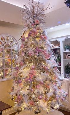 a white christmas tree with pink and gold ornaments