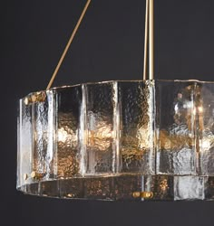 a chandelier made out of glass blocks hanging from a metal rod with two lights on each end