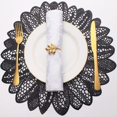 a white plate topped with a napkin next to a fork and knife on top of a doily