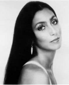 black and white photograph of a woman with long dark hair, wearing large hoop earrings