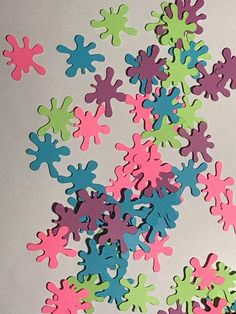 a bunch of different colored splots on a white surface with one being cut out