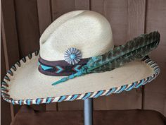 The Thunderbird starts with a Mexican soft palm Gus hat body that has a 4" brim and 5 1/2" crown. Hand laced in three colors of leather lace - chocolate brown, turquoise and saddle. The beaded hatband has a thunderbird pattern and is mounted on chocolate suede. The back of the band has a deer antler bead for accent. Large antiqued Concho with a faux turquoise stone. A massive barred turkey feather dyed in turquoise completes the hat. All hats are made to order. Allow up to 4 weeks for your hat t Antler Beads, Jordan Hats, Couture Hats, Hat Holder, Painted Hats, Rancher Hat, Turquoise Accents, Turkey Feathers, Diy Hat