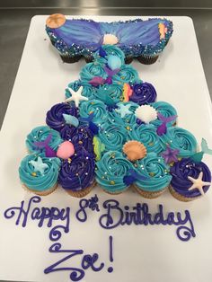 a birthday cake decorated with blue frosting and stars on the top is an image of a dress made out of cupcakes