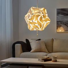 a living room with a couch, coffee table and lamp hanging from it's ceiling