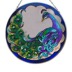 a stained glass peacock is hanging from a chain on a white wall with a circular mirror in the shape of a circle