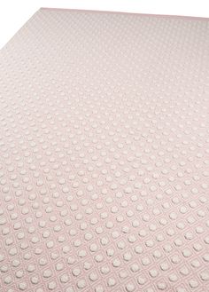 a pink rug with white dots on it