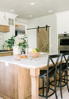 a kitchen with an island and chairs in it