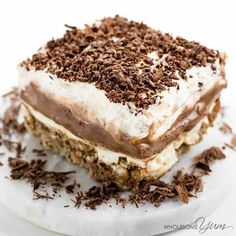 a piece of cake with chocolate shavings and whipped cream frosting on top