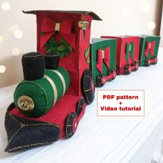 a small train made out of felt sitting on top of a table next to christmas decorations