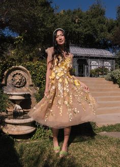 a woman standing in front of some steps wearing a dress that has flowers on it