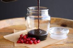 someone pours red wine into a jar with pomegranate on the table