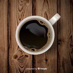 a cup of coffee sitting on top of a wooden table