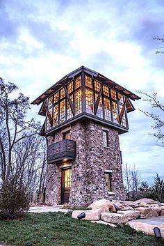 a stone tower sitting on top of a lush green hillside