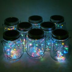 there are many mason jars with lights in them