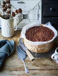 a cake sitting on top of a cooling rack next to a cup and spoons