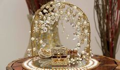 a gold and white jewelry set sitting on top of a wooden table next to a vase