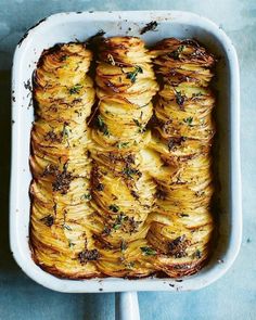 a casserole dish filled with potatoes and herbs