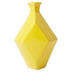 a yellow vase sitting on top of a white table