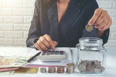 a woman sitting at a table with money and calculator in front of her