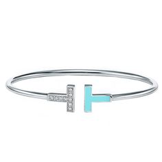 This modern bracelet is enhanced with diamonds and turquoise, a favorite stone of Tiffany designers for over a century. The natural formation of the stone creates subtle differences in appearance, ensuring each piece is as unique as its wearer. As multifaceted as it is iconic, the Tiffany T collection is a tangible reminder of the connections we feel but can't always see. Wear this sleek design in a mixed-metal bracelet stack for a bold look.Details:Brand: Tiffany & CoTotal Carat Weight: 0.11Siz Tiffany Wire Bracelet, Tiffany & Co. Bracelet, Luxury Sterling Silver Turquoise Bracelet, Luxury Turquoise Sterling Silver Bracelets, Modern Turquoise Bracelet Jewelry, Modern Turquoise Bracelet, Luxury Turquoise Bangle Bracelets, Tiffany Bracelet, Modern Bracelet