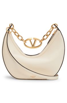 A gleaming chain centered with a VLOGO insignia spans the top of this hobo crafted from calfskin leather in a perfectly slouchy silhouette. Top zip closure Shoulder strap Leather lining Leather Made in Italy Designer Handbags Elegant White Shoulder Bag With Logo Plaque, Evening Bags With Logo Charm, Chic Evening Bags With Logo Charm, Elegant Evening Bag With Logo Charm, Chic Gold Bag With Logo Charm, Closet Luxury, Digital Wardrobe, Valentino Bag, Bag With Chain