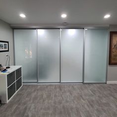 an empty room with sliding glass doors on the wall and wood flooring in front of it