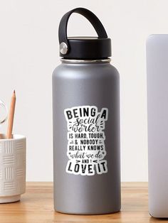 a stainless steel water bottle sitting on top of a wooden table