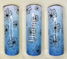 three blue tumbles with flowers painted on them